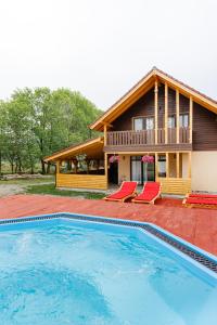 una casa con piscina di fronte a una casa di Flori din Deal a Mărgău