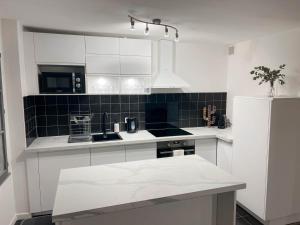 a kitchen with white cabinets and a black and white appliances at Vieux Nice - Wifi, AC, 5 pers in Nice