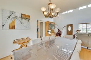 ein Esszimmer mit einem Glastisch und einem Kronleuchter in der Unterkunft Lake Elsinore Vacation Rental about 4 Mi to the Lake! in Lake Elsinore