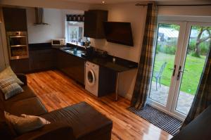 a living room with a kitchen with a washer and dryer at The Annexe @ Woodland in Bury