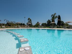 a large swimming pool with chairs and umbrellas at Ville d'Ogliastra 2 - Marina Suites in Cardedu