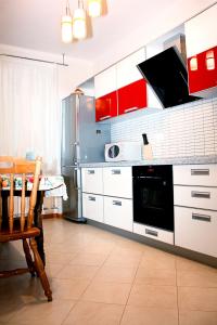 a kitchen with red and white cabinets and a table at Alliance Apartments na Gazetnom in Rostov on Don