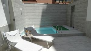 une baignoire jacuzzi avec deux chaises et une table dans l'établissement Sisina Luxury Room Jacuzzi & Piscina, à Portici