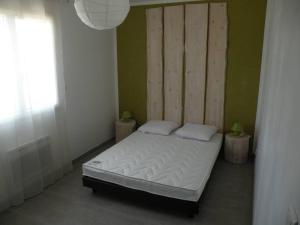 um quarto com uma cama e uma parede verde em villa pour 10 personnes avec piscine et jacuzzi em Alès