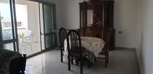 uma sala de jantar com mesa e cadeiras e uma varanda em Zomoroda North Coast Chalet by Solid Pro em Dawwār Shindī Fannūsh