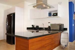 a kitchen with a counter with a sink and a refrigerator at New Condo with Pool, Gym, A/C, WiFi, King Size bed in Cancún
