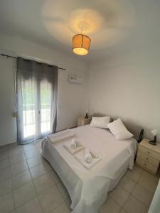 a bedroom with a white bed and a window at Males House in Malles