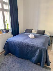 a bed with a blue comforter in a bedroom at Wonder studio apartment prime location and commute in the heart of Kallio in Helsinki