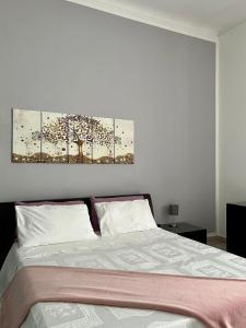 una camera da letto con un letto e due dipinti alle pareti di Alsimica Apartment a Taranto