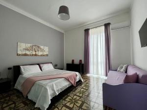 una camera con letto, finestra e divano di Alsimica Apartment a Taranto
