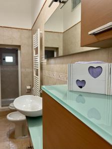 bagno con servizi igienici e scatola con cuori di Alsimica Apartment a Taranto