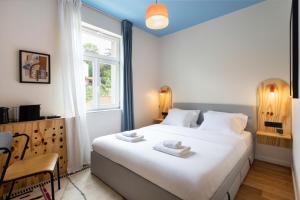 a bedroom with a large white bed with a window at Flok Tkalciceva - Main Street Rooms & Apartments in Zagreb