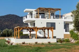 een wit huis met een houten prieel bij Lamzi's Residence in Chania