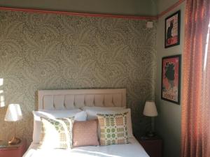 a bedroom with a bed and a wall with wallpaper at No. 30 in Aberdare