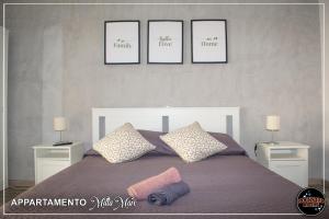 une chambre avec un lit avec trois tableaux au mur dans l'établissement MILLAMARE, à Lido di Ostia