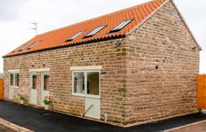 a brick house with a red roof and windows at The Old Threshing Barn in Newark upon Trent