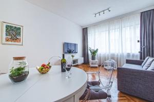 a white kitchen and living room with a couch at Vlaska 69 Spacious & Central one bedroom apartment 60 m2 in Zagreb