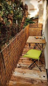 a table and a green chair on a wooden deck at Bonaca Apartments in Budva