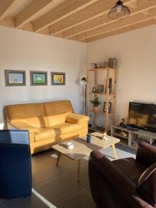 Una sala de estar con un sofá y un televisor. en La cabane du banc José, en Le Rozel 10 fotos más