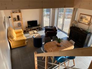 una sala de estar con una mesa y sillas en La cabane du banc José, en Le Rozel