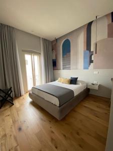 a bedroom with a large bed and a large window at Nonno Nicola Rooms in Bari