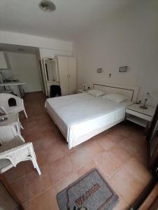 a bedroom with a large white bed and a tiled floor at St George's House in Potistika