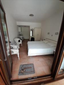 a bedroom with a large white bed and chairs at St George's House in Potistika