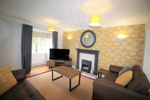 a living room with a couch and a fireplace at 3 Bed Detached - Sleeps 5 - Private Garden & Parking Plus Garage - Quiet Cul De Sac Location - Dog Friendly - Fast Wifi - Close to Motorway Access in Doncaster