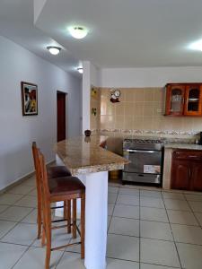 a kitchen with a table and some chairs in it at Acogedora Casa in Managua