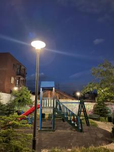 a playground with a slide next to a street light at G32 in Tbilisi City