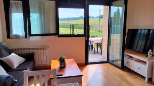 a living room with a couch and a tv and a table at El Mirador del Valle, a 9 min de Comillas in Comillas