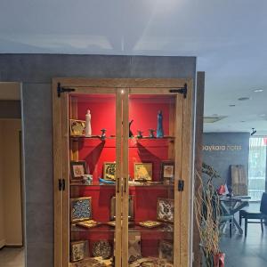 Habitación con puerta de cristal y pared roja. en Baykara Hotel, en Konya