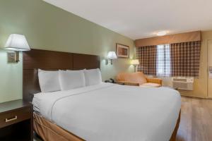 ein großes weißes Bett in einem Hotelzimmer in der Unterkunft University Inn and Suites Eugene in Eugene