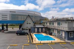 a building with a swimming pool in a parking lot at University Inn and Suites Eugene in Eugene