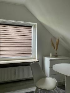 uma cadeira e uma mesa num quarto com uma janela em 2- Zimmer Wohnung em Lehrte
