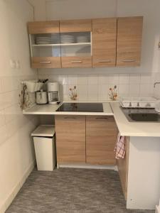 a small kitchen with wooden cabinets and a sink at Simply House in Balatonboglár