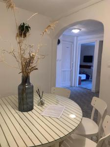 a dining room table with a vase with flowers on it at Simply House in Balatonboglár +14 photos