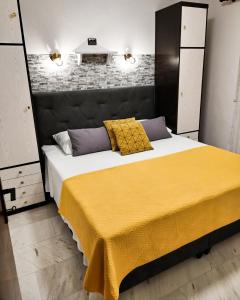 a bedroom with a large bed with a yellow blanket at Beachfront Apartment Nikol in Zaboric