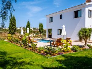 a villa with a swimming pool and lawn at Sunny Paradise Luxury Villa With Pool & Hot Tub in Paphos City
