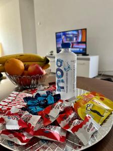 einen Teller mit einer Flasche Soda und einer Schale Obst in der Unterkunft Apartment Nest Stolac in Stolac