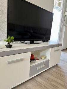 einen Flachbild-TV auf einem weißen Entertainment-Center in der Unterkunft Apartment Nest Stolac in Stolac
