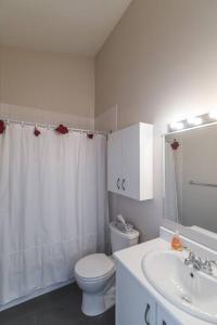 a white bathroom with a toilet and a sink at Le Bionick 46 (CITQ 312093) in Stoneham