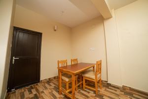 una sala da pranzo con tavolo, sedie e porta di Subedi Apartment a Pokhara