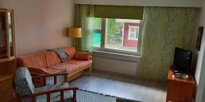a living room with a couch and a window at Saimaan Kodikas in Savonlinna
