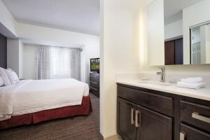 a bathroom with a bed and a sink in a room at Residence Inn Minneapolis Downtown/City Center in Minneapolis