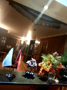 a room with a table with flowers and a sailboat on it at Baykara Hotel in Konya