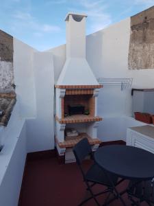 a kitchen with a fireplace with a table and chairs at Moradia Rocleo Tavira House in Tavira