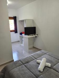 a bedroom with a bed and a desk and a computer at Pousada do Pórtico in Gramado