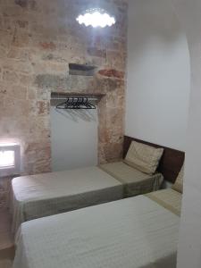 una camera con due letti e un muro di mattoni di Trullo Victory a Martina Franca