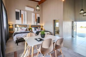una camera con letto, tavolo e sedie di Summer PALACE Guesthouse a Bloemfontein